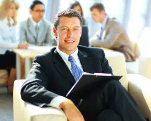 A man in suit and tie holding a book.